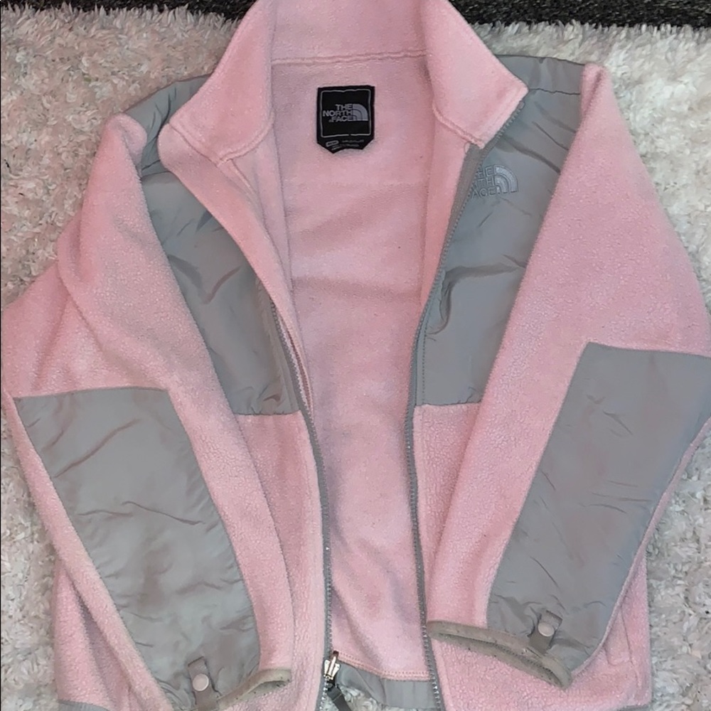 A pink and grey north face jacket